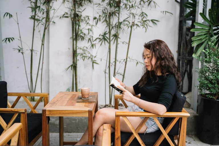 Person peacefully reading in a quiet public space like a library or coffee shop