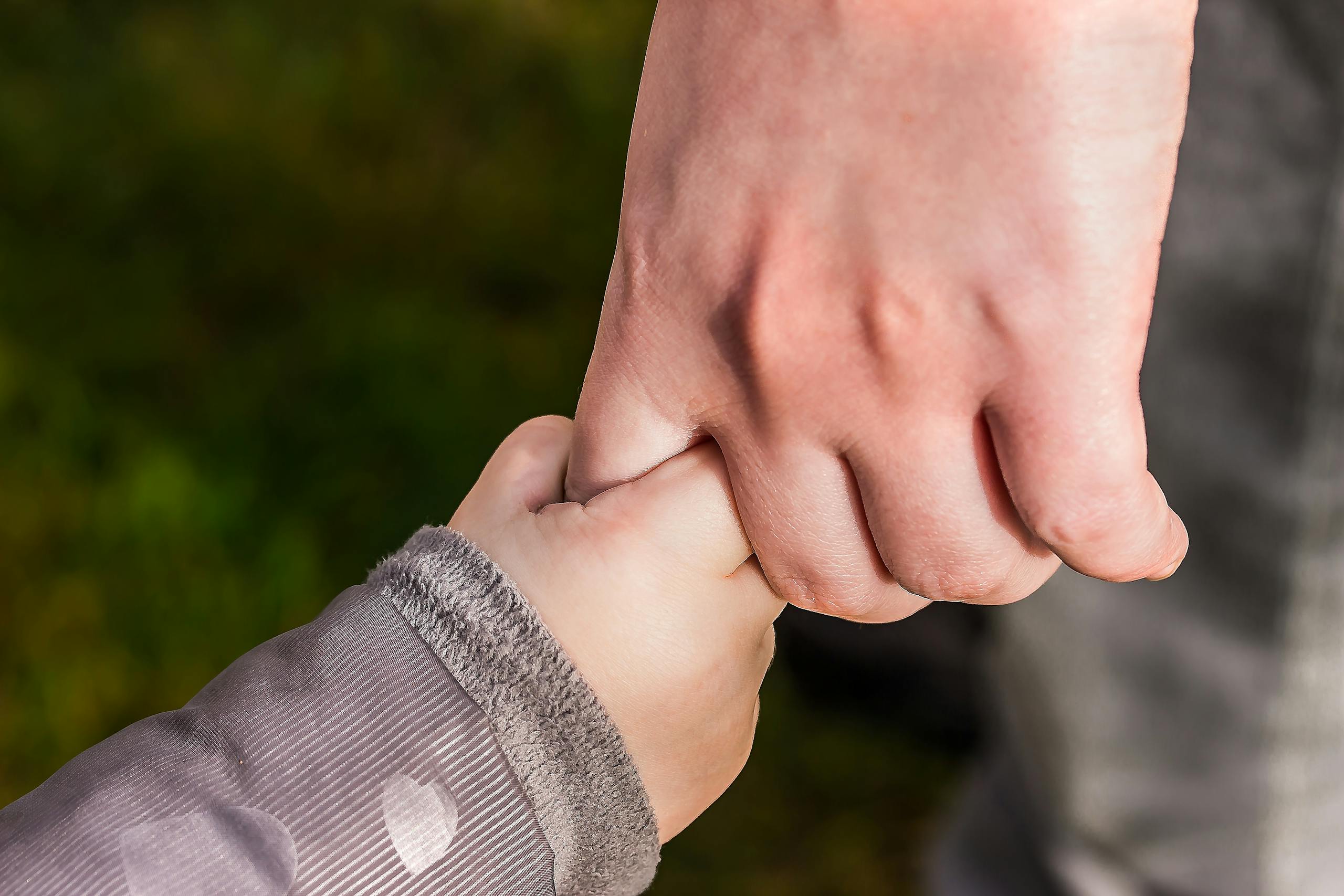 Parent and child sharing a quiet moment outdoors in a suburban park representing family connection