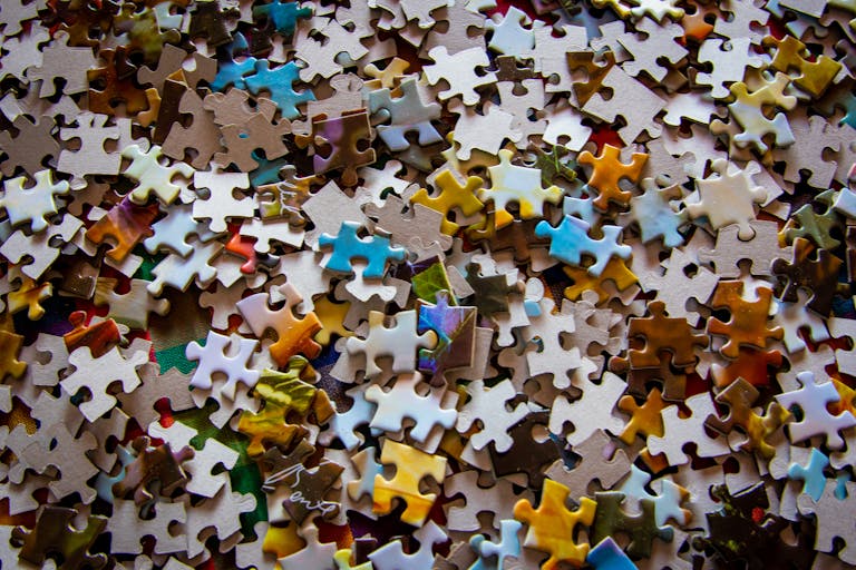A close-up view of colorful jigsaw puzzle pieces scattered on a surface.