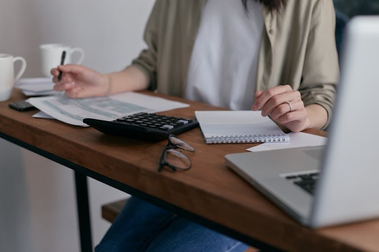 Introvert reviewing financial planning documents at a quiet desk with organized folders and calculators