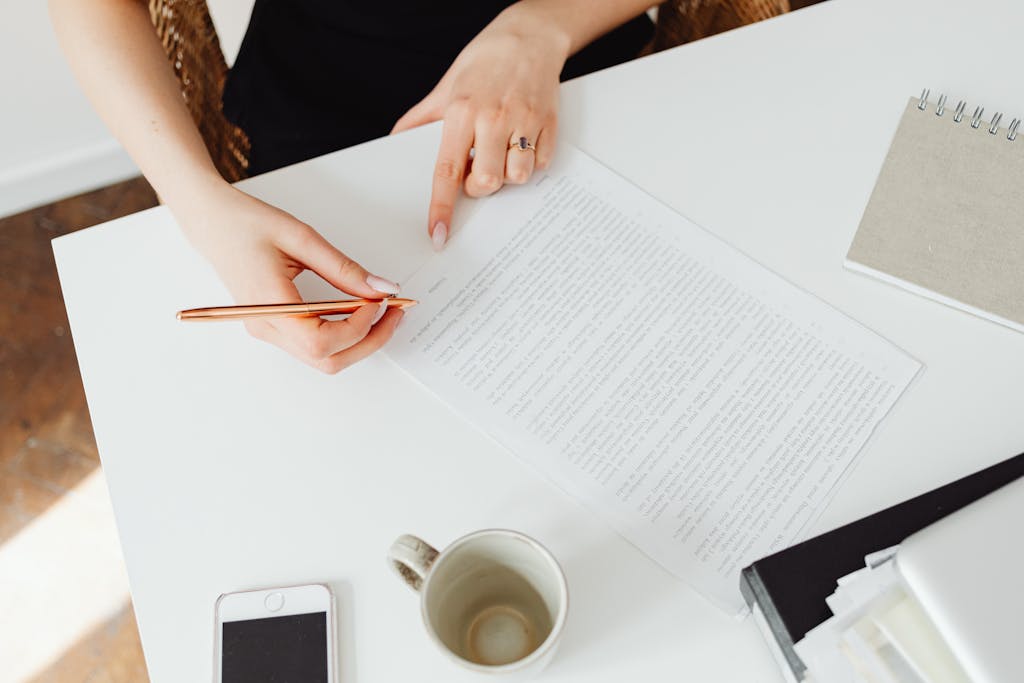 Professional introvert woman carefully reviewing sales documents and contracts at organized workspace, demonstrating thorough preparation and analytical approach to sales success