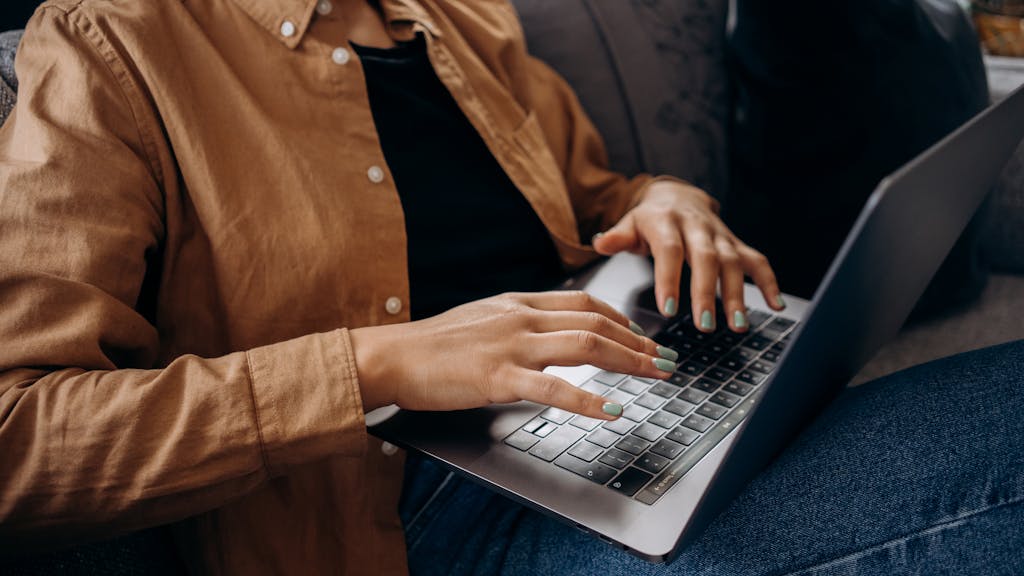 Professional in their 40s working on laptop learning to code, showing focused concentration and determination in a quiet home office setting