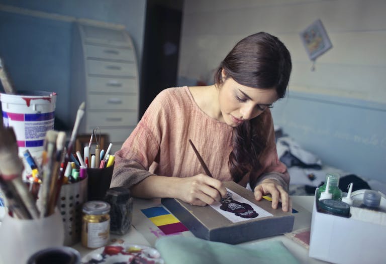 Creative workspace with art supplies and journal, representing emotional processing through creative expression