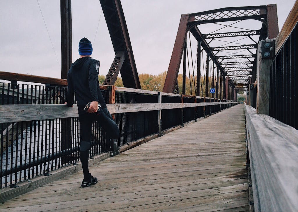 Professional man stretching during outdoor exercise showing stress relief and workplace anxiety management through physical activity