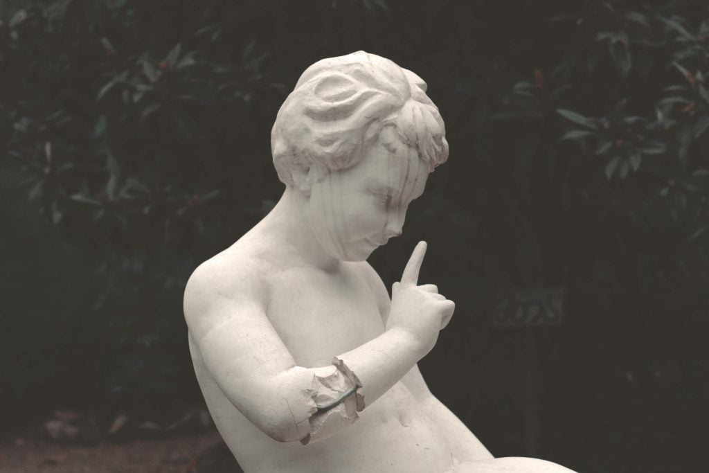 Classical statue in contemplative pose representing introvert preference for quiet reflection and meaningful thought over superficial small talk conversations