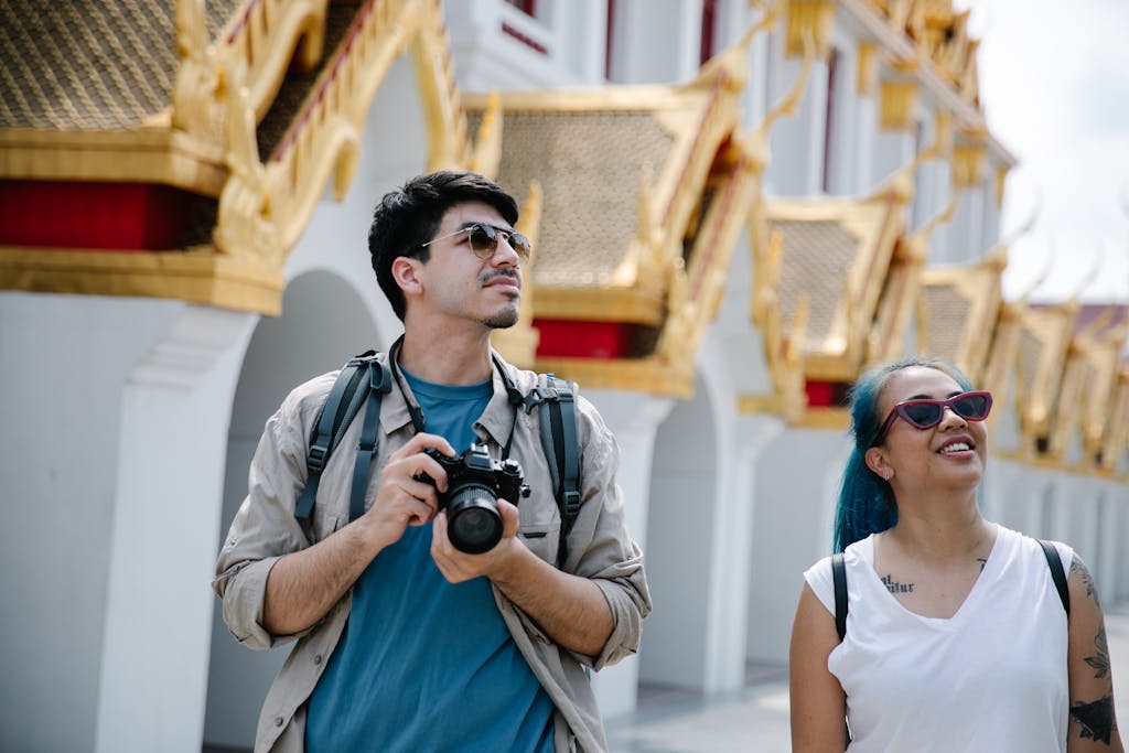Small group of introvert-friendly travelers exploring Asian temple at their own pace with cameras