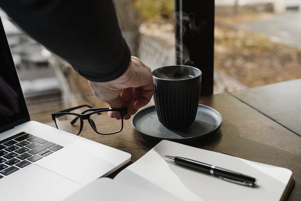 Introvert taking a mindful coffee break during work to manage energy and avoid perfectionism while adapting to change
