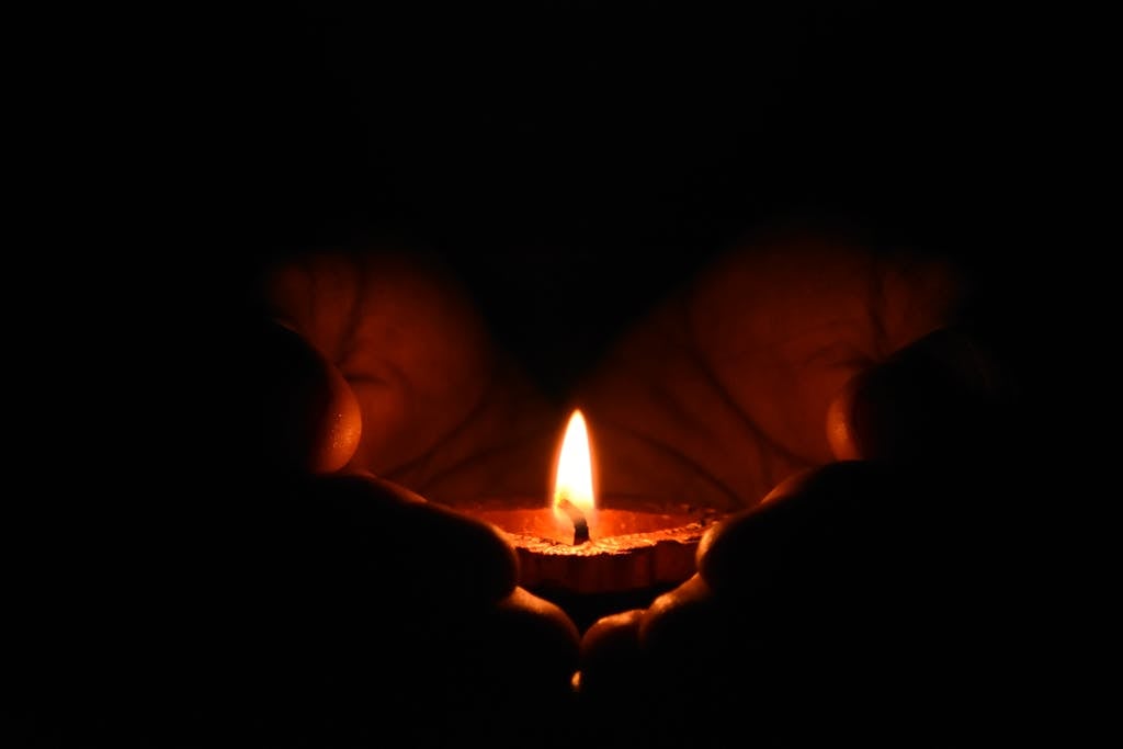 Sehnsucht spiritual longing - hands embracing candlelight representing inner warmth and transcendent yearning