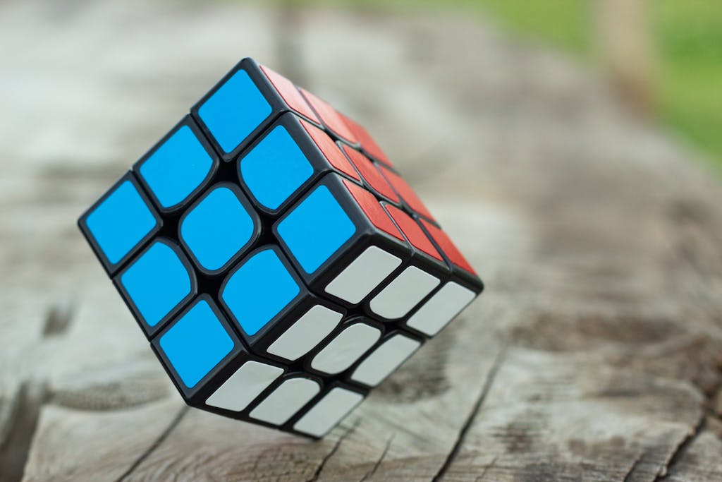 INFJ paradoxes complexity - colorful Rubik's Cube resting on a wooden surface showcasing vibrant geometric patterns, representing the multifaceted and complex nature of INFJ personality contradictions