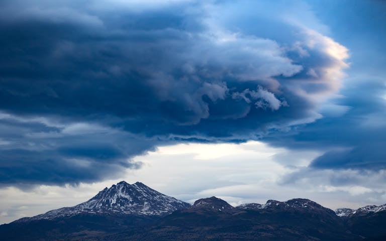 Epic clouds loom over the snowy peaks of Patagonia, Chile, creating a dramatic and breathtaking landscape.