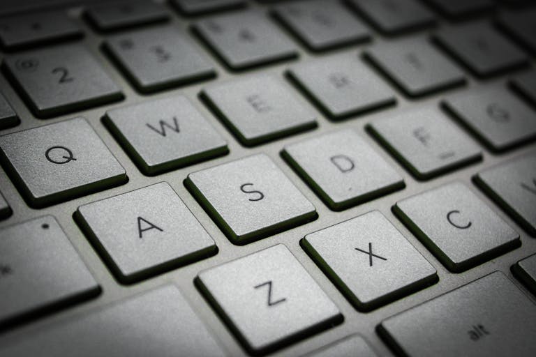 A detailed macro shot of a sleek modern computer keyboard featuring the QWERTY layout.