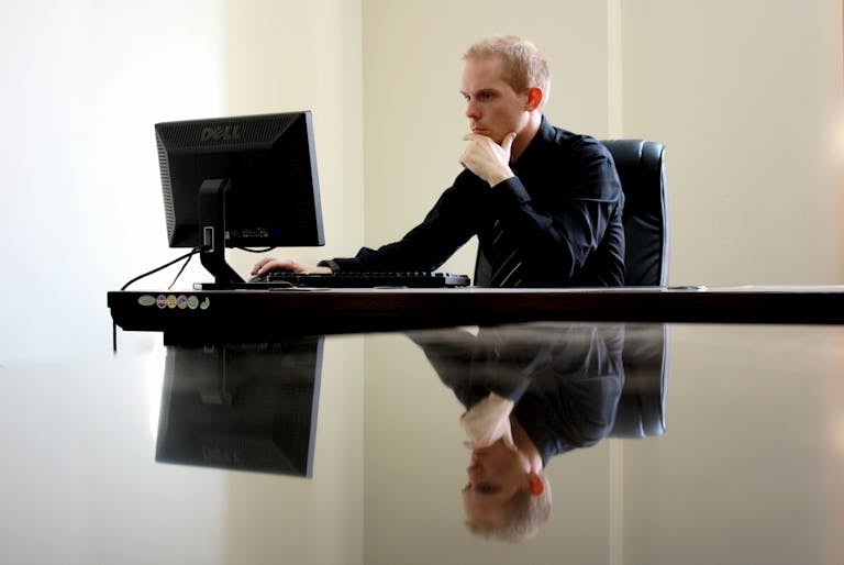 A businessman in deep thought at his desk, reflecting on work tasks.