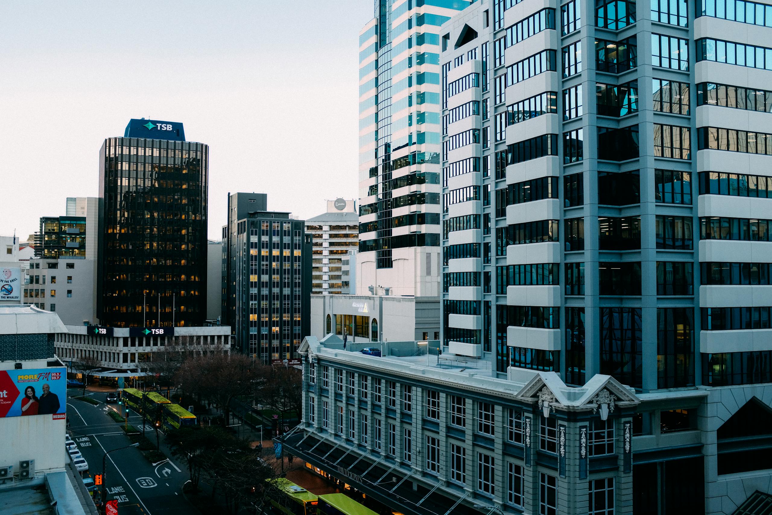A bustling urban skyline with modern skyscrapers and city streets during the day.