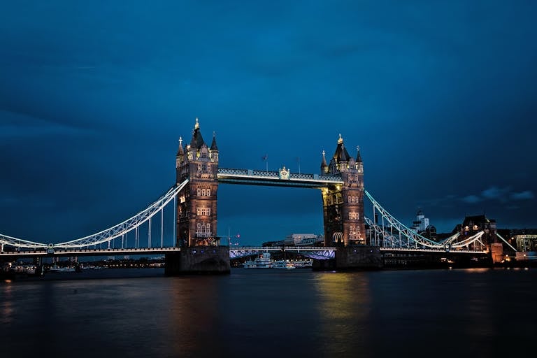 A stunning view of the illuminated Tower Bridge in London against a deep blue night sky.