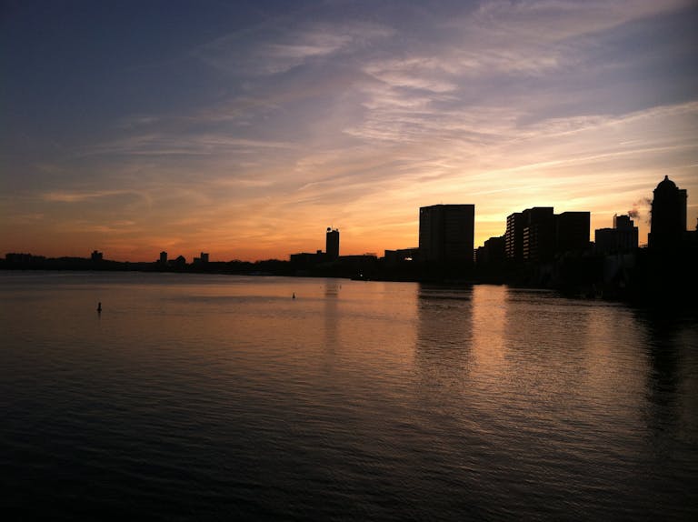Captivating view of Boston's skyline in silhouette against a colorful twilight sky.