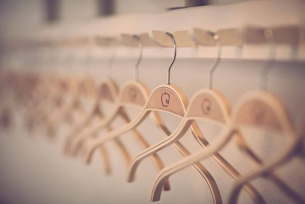 Close-up of neatly organized wooden hangers in a modern indoor wardrobe setting.