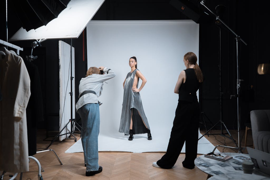 Dynamic studio fashion photoshoot with model and photographers in action.