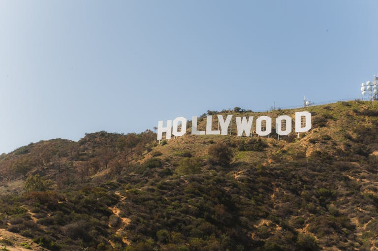 Famous Hollywood Sign on hillside under clear blue sky in Los Angeles, California.