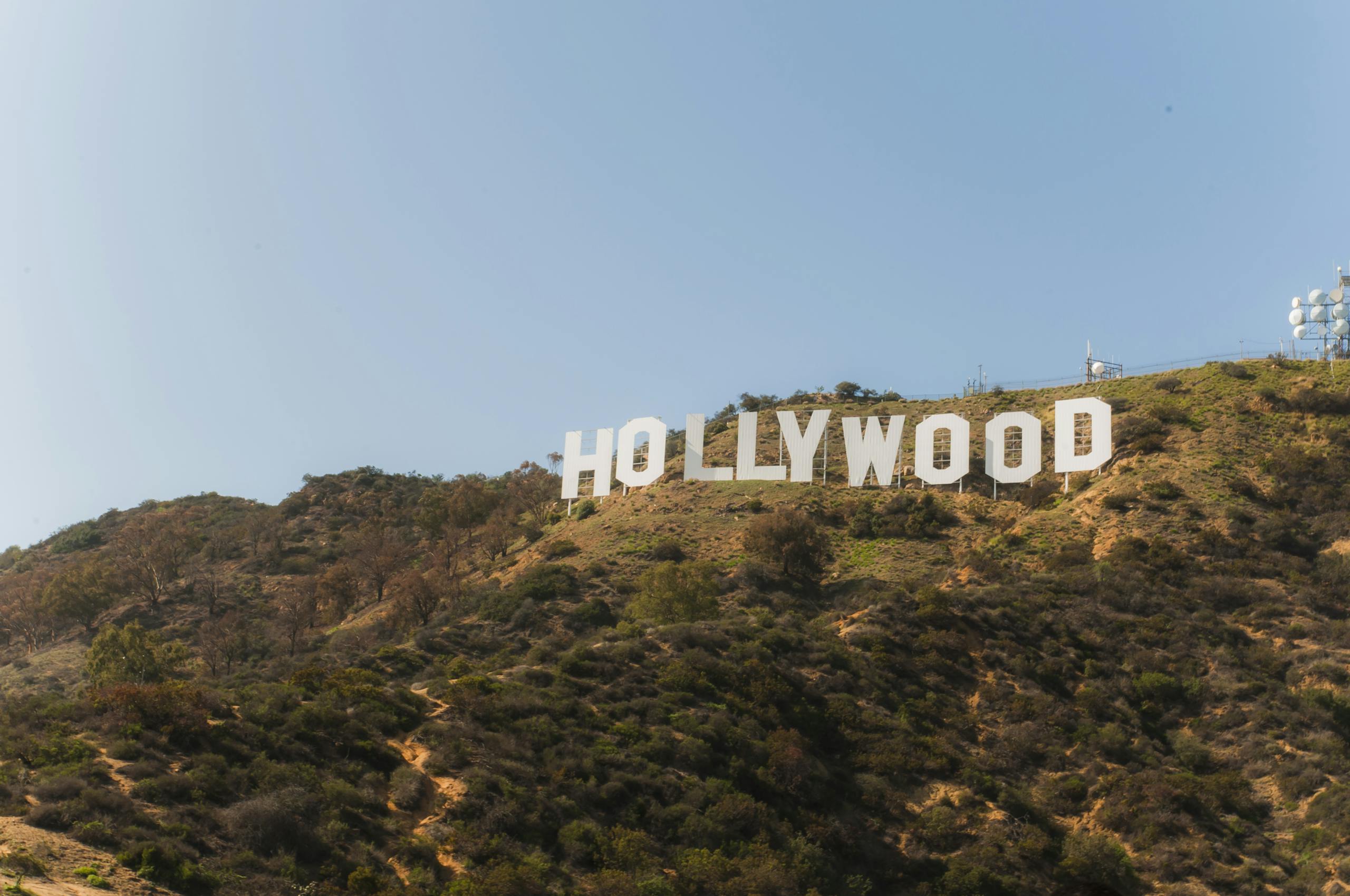 Famous Hollywood Sign on hillside under clear blue sky in Los Angeles, California.