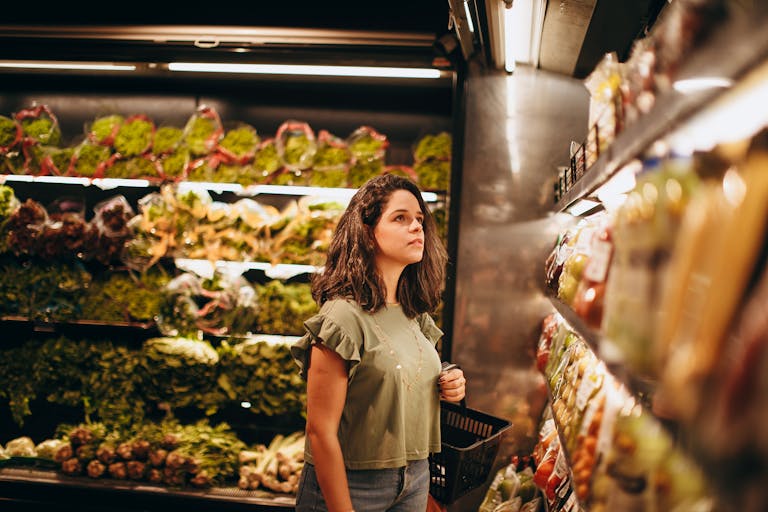 Introvert standing alone in a quiet grocery store aisle early in the morning with soft lighting and empty aisles creating a calm shopping environment