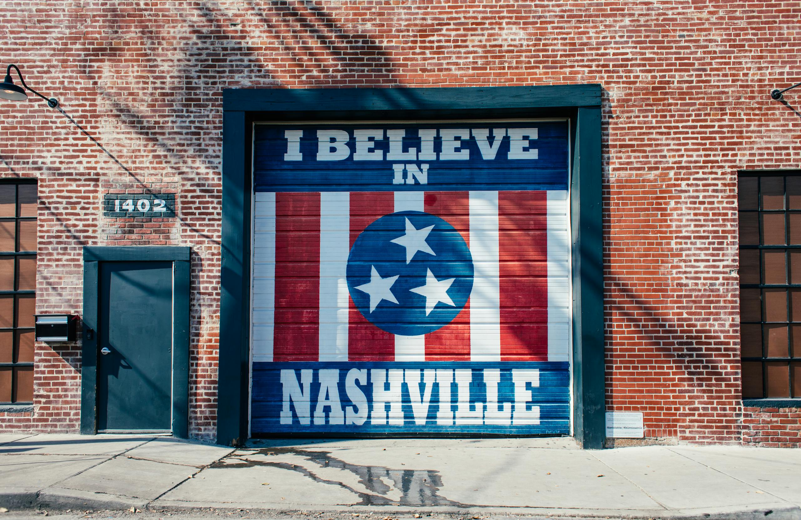 Mural featuring 'I Believe in Nashville' painted on a brick building facade.