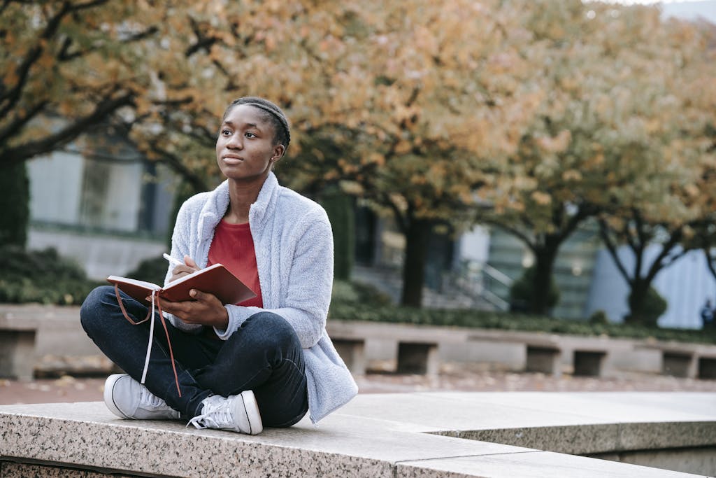 Person reflecting quietly in a peaceful natural setting, representing self-awareness and mental health baseline assessment