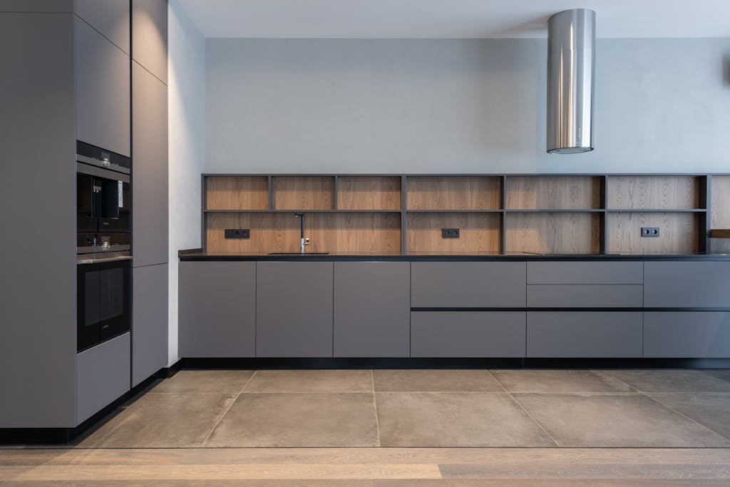 Spacious and sleek modern kitchen with minimalist gray cabinets and efficient layout.