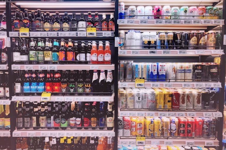 Wide variety of bottled and canned beers displayed on store shelves in Shanghai, China.