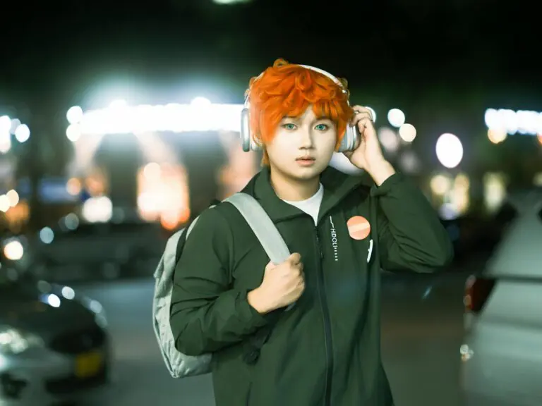 Young person with orange hair wearing headphones, introspective urban night setting