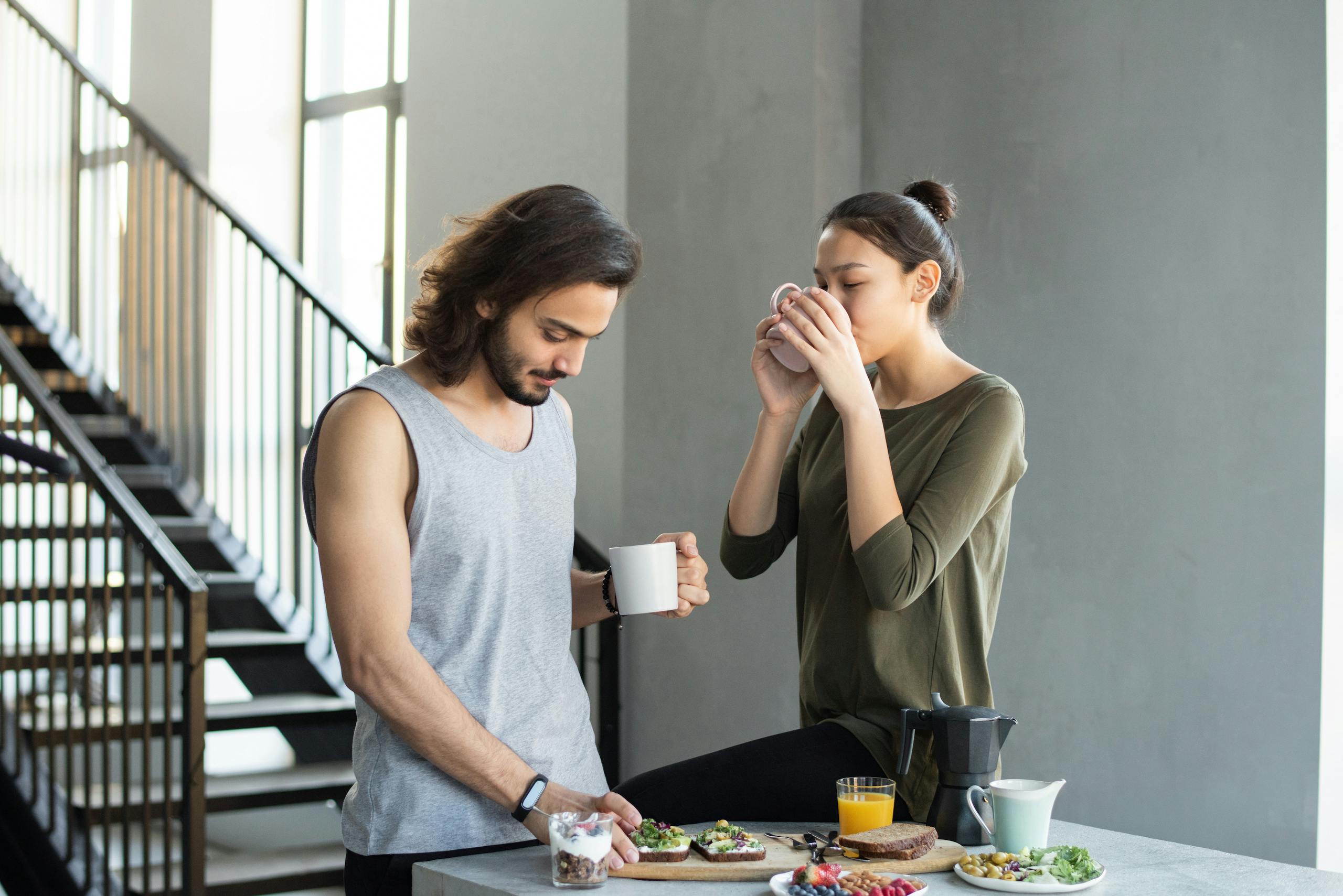 Couple enjoying cozy breakfast with coffee and juice in modern home kitchen