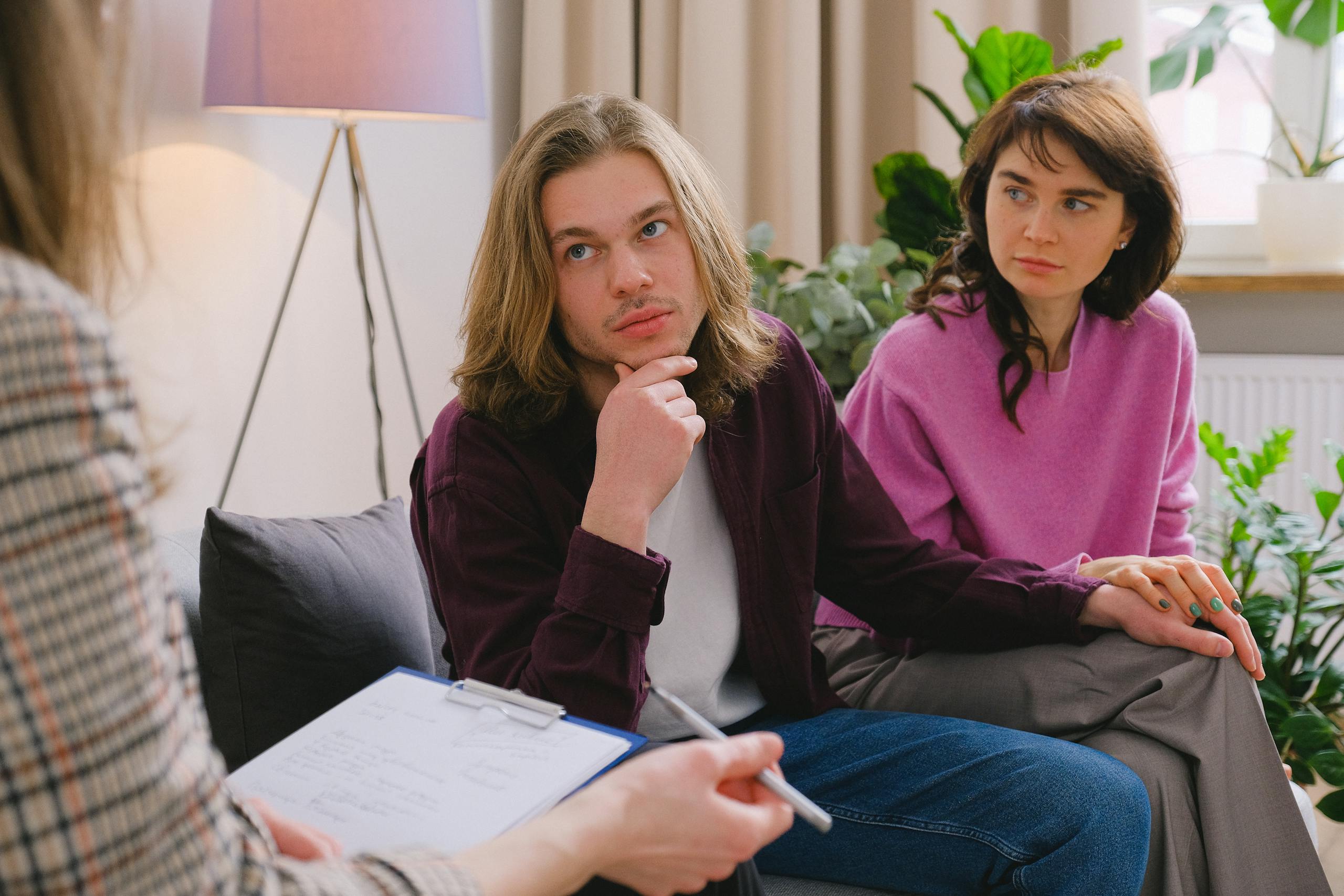 Couple holding hands during therapy session in office setting