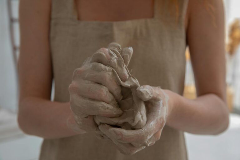 Craftswoman kneading clay in indoor workshop showcasing detailed hands-on craftsmanship
