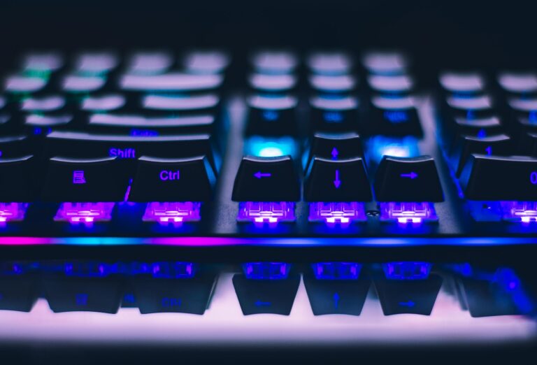 Close-up of illuminated mechanical keyboard with blue purple lights