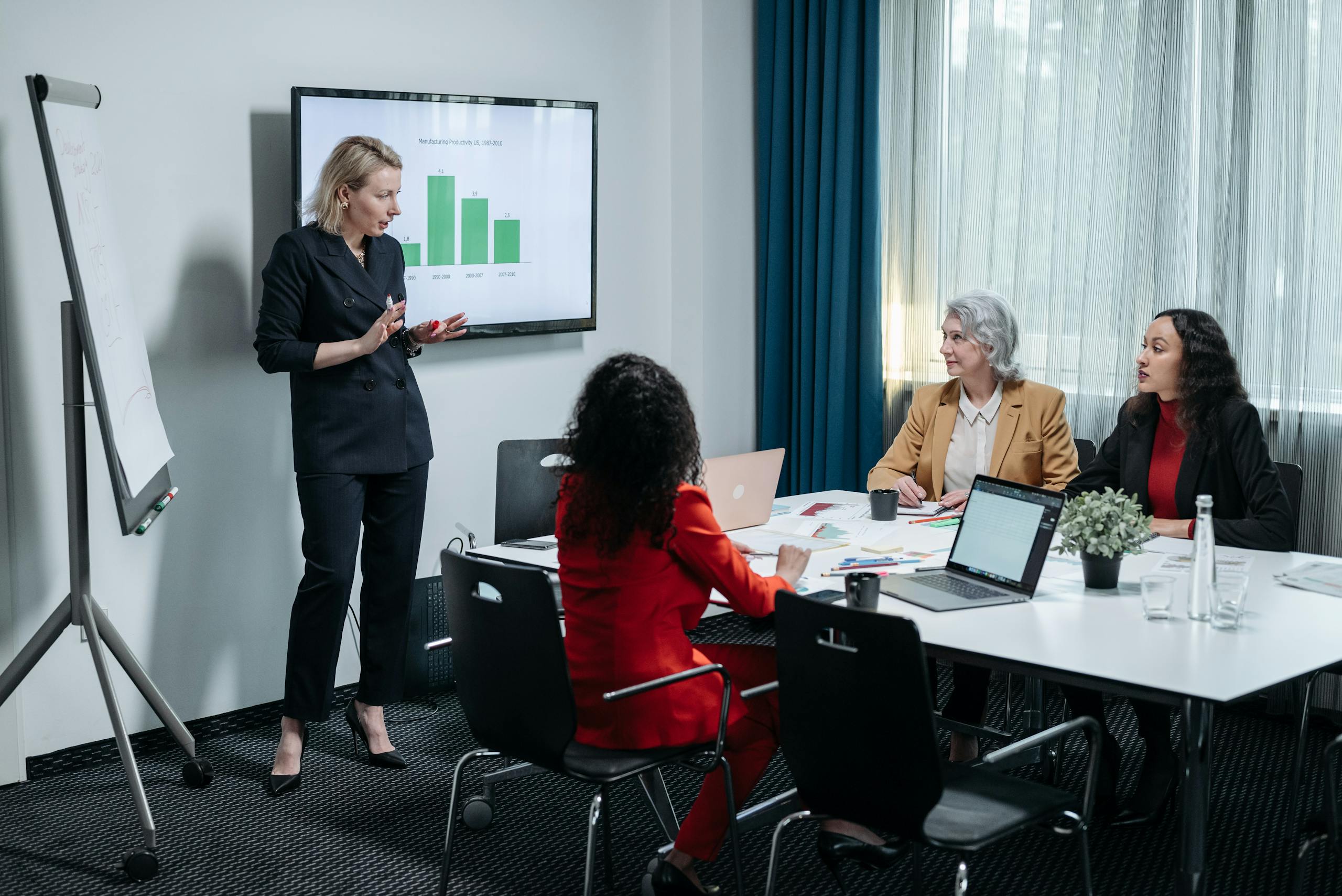 Group of professional women presenting and engaging in modern conference room setting