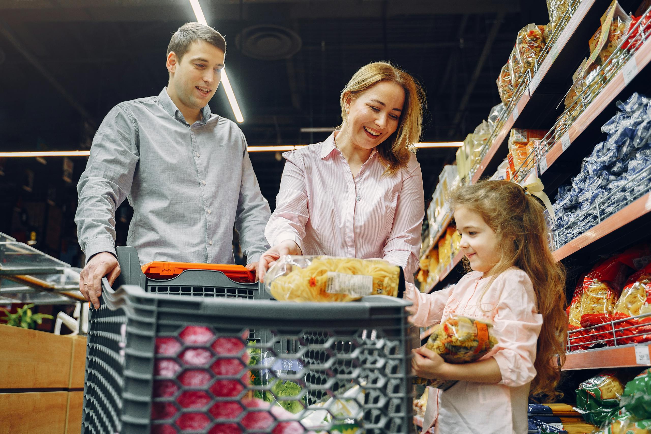 Joyful family of three shopping together in supermarket creating memories
