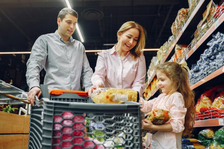 Joyful family of three shopping together in supermarket creating memories