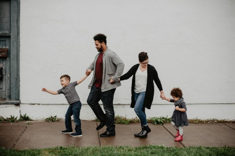 Joyful family walking together outdoors holding hands playfully