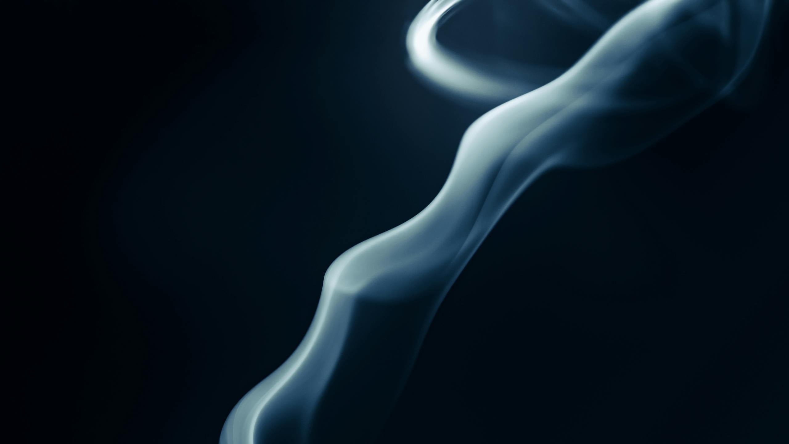 Abstract close-up of swirling smoke patterns against dark background creating mesmerizing effect.