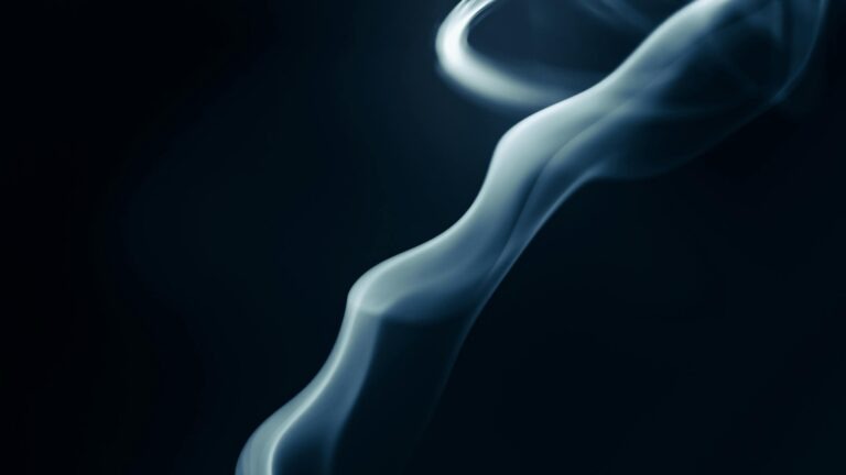 Abstract close-up of swirling smoke patterns against dark background creating mesmerizing effect.