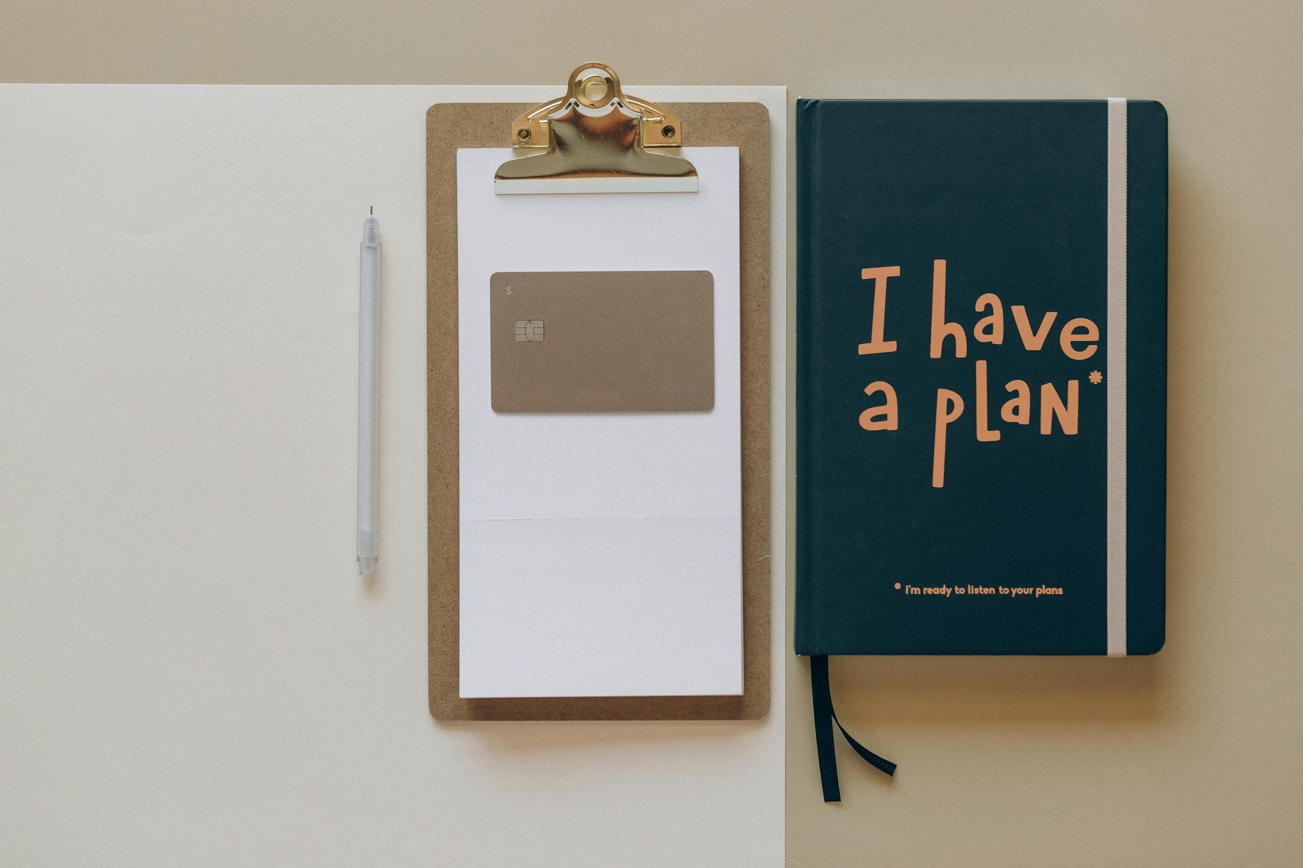 Minimalist office setup with planner clipboard, card, and pen for organization.