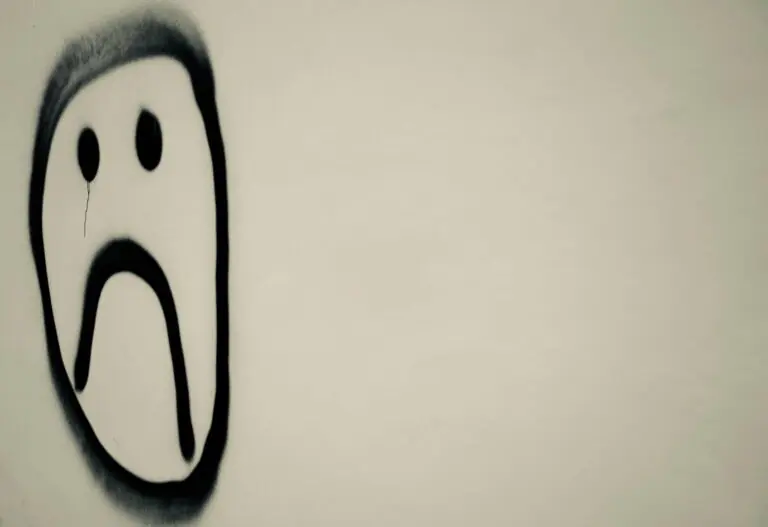 Monochrome graffiti sad face on urban wall expressing emotional melancholy symbolically