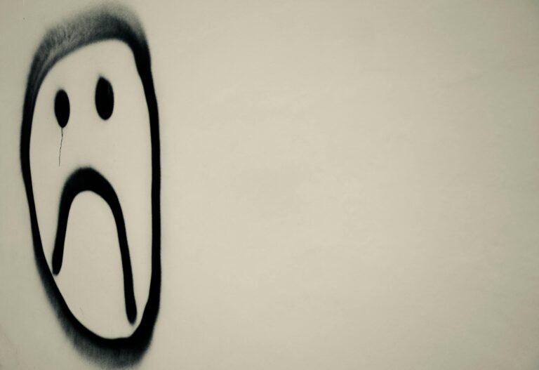 Monochrome graffiti sad face on urban wall expressing emotional melancholy symbolically