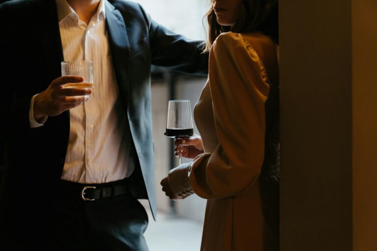 Stylishly dressed couple sharing romantic moment with drinks at upscale venue