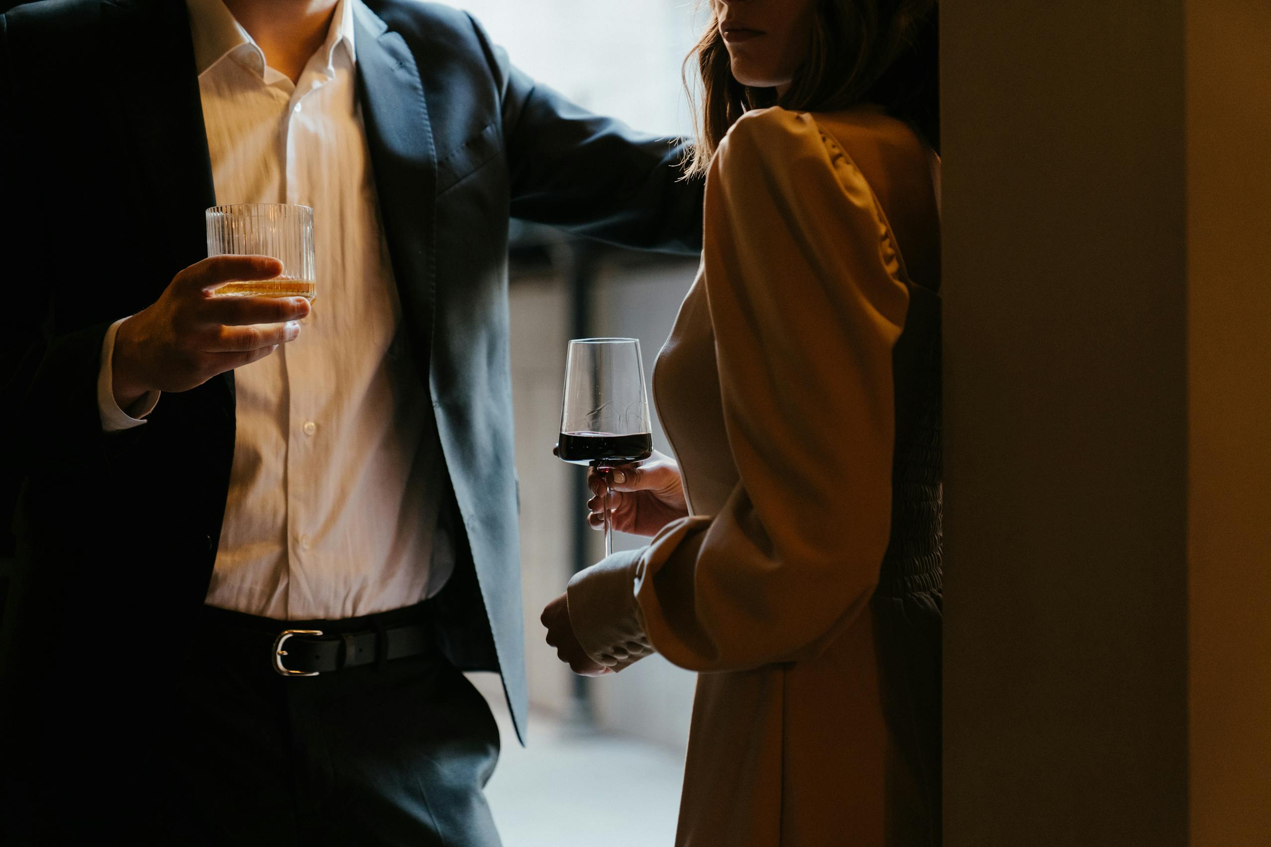 Stylishly dressed couple sharing romantic moment with drinks at upscale venue