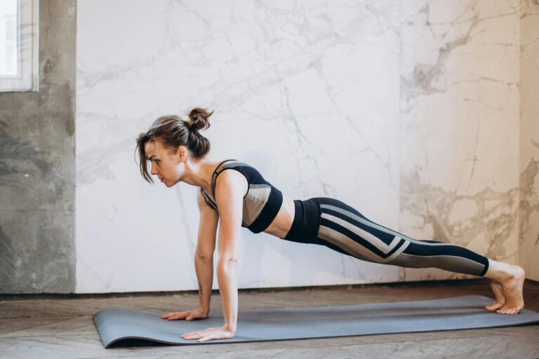 Woman performing a plank pose on yoga mat indoors showcasing strength and focus
