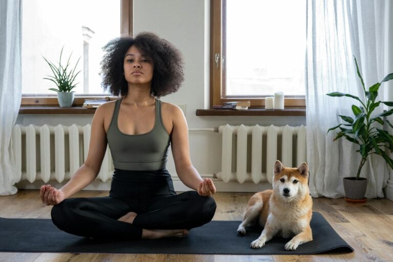 Woman practices yoga at home with shiba inu dog in relaxing morning setting.