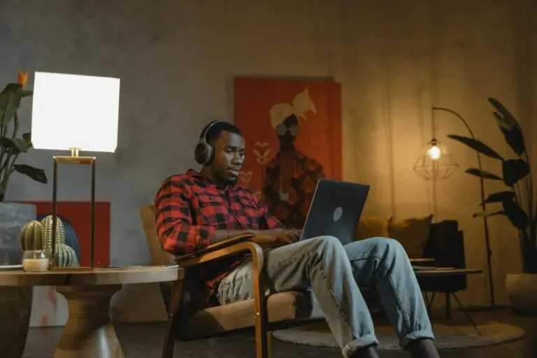 African American man working on laptop indoors embracing remote work lifestyle.