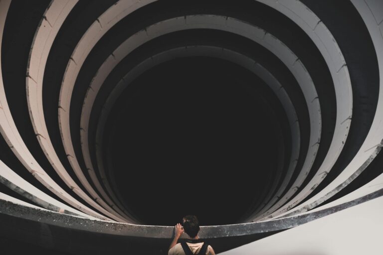 Person looking into spiral tunnel suggesting depth and mystery