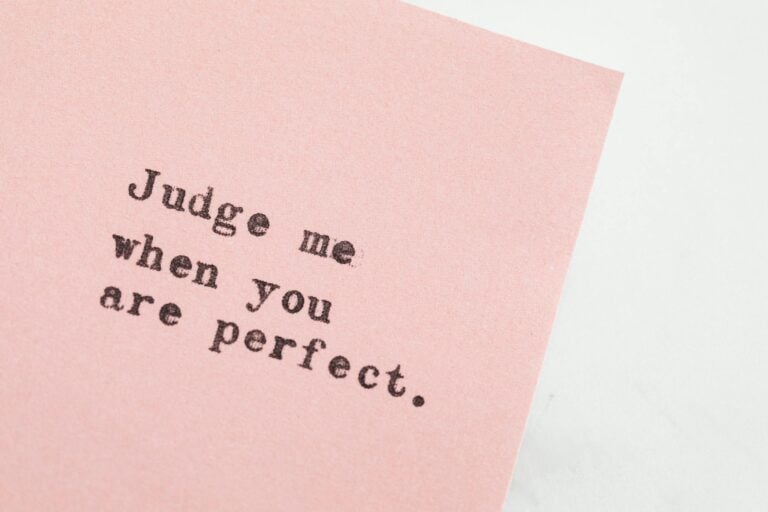 Inspirational quote on pink paper about judgment and perfection message