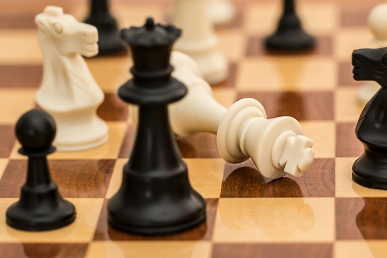 Close-up chess pieces on board depicting strategy and intellectual challenge.